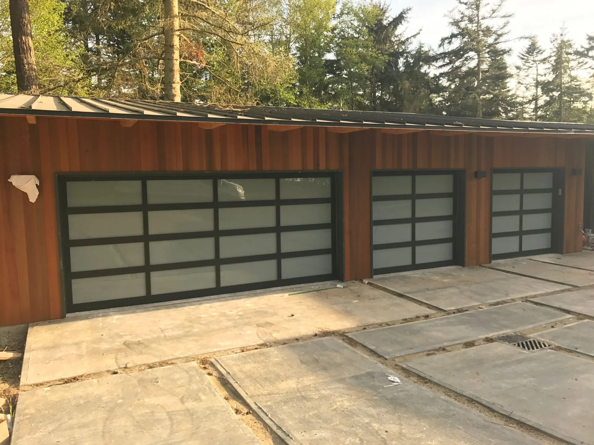 16x7 and 9x7 Alumadoor garage doors with black frames and white glass